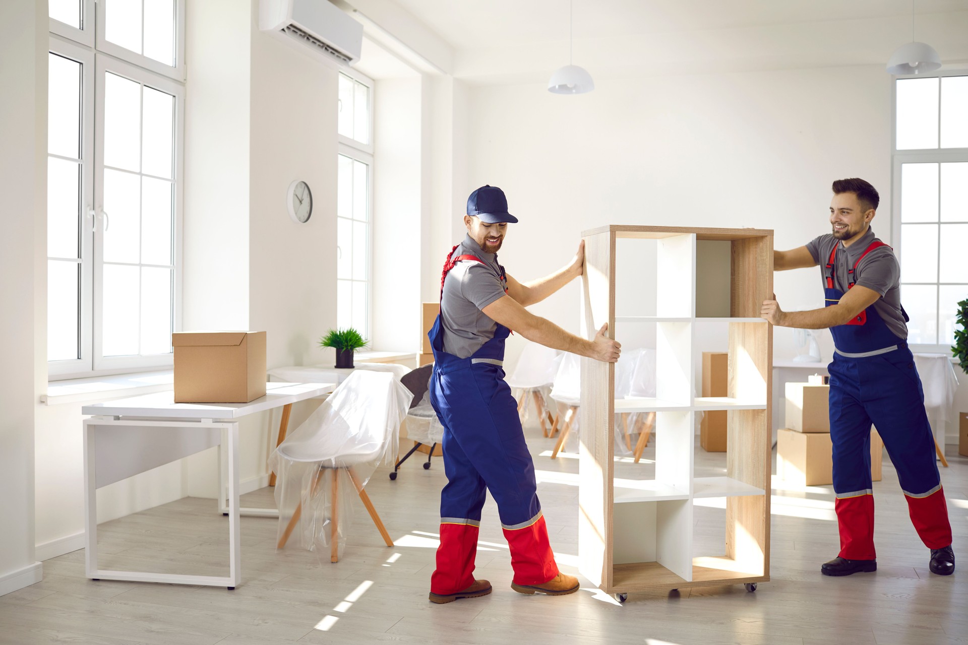 Male movers help client with furniture unloading